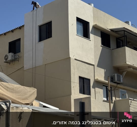 עבודת צביעת חזית בניין בגובה באמצעות סנפלינג